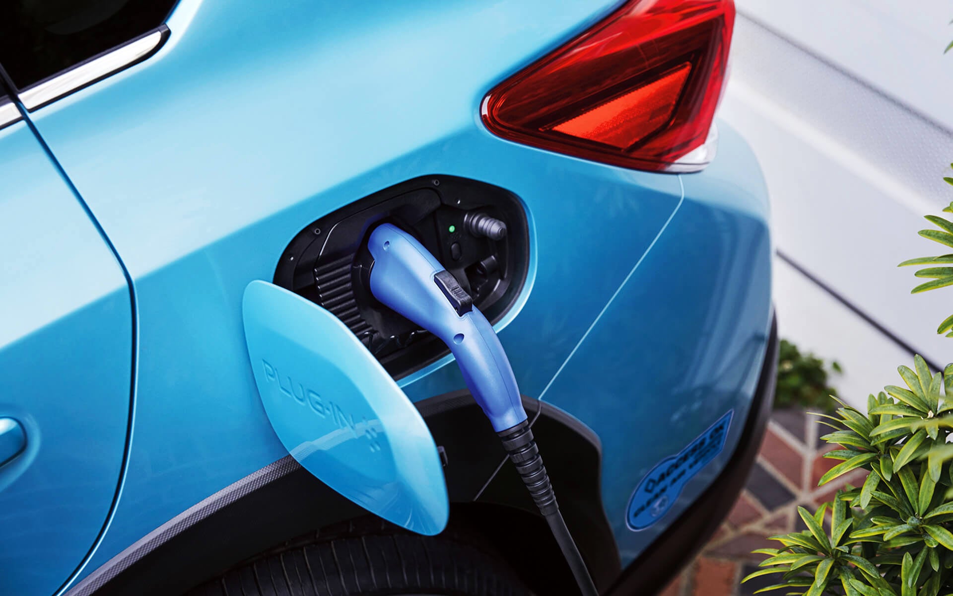 A close-up of the Subaru Crosstrek Hybrid's charging port with charging cable plugged in | Subaru Superstore of Surprise in Surprise AZ