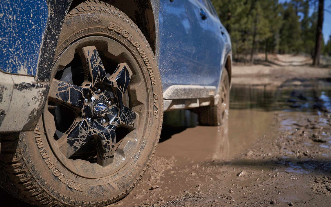 A Subaru Outback Wilderness with a dirty wheel