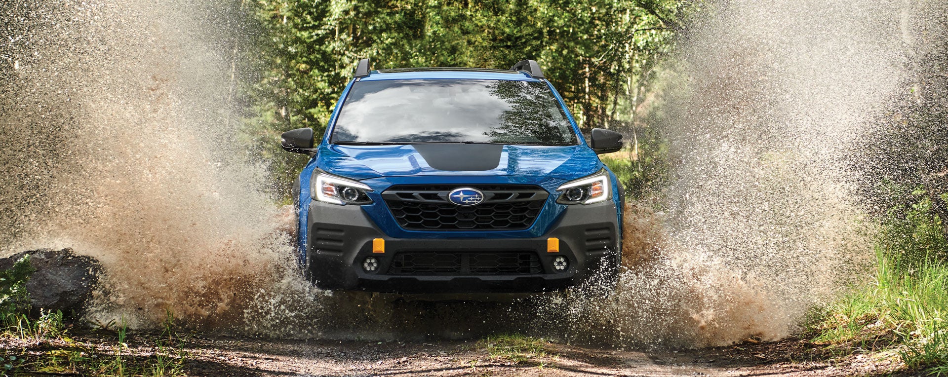 A 2023 Outback Wilderness driving on a muddy trail. | Subaru Superstore of Surprise in Surprise AZ